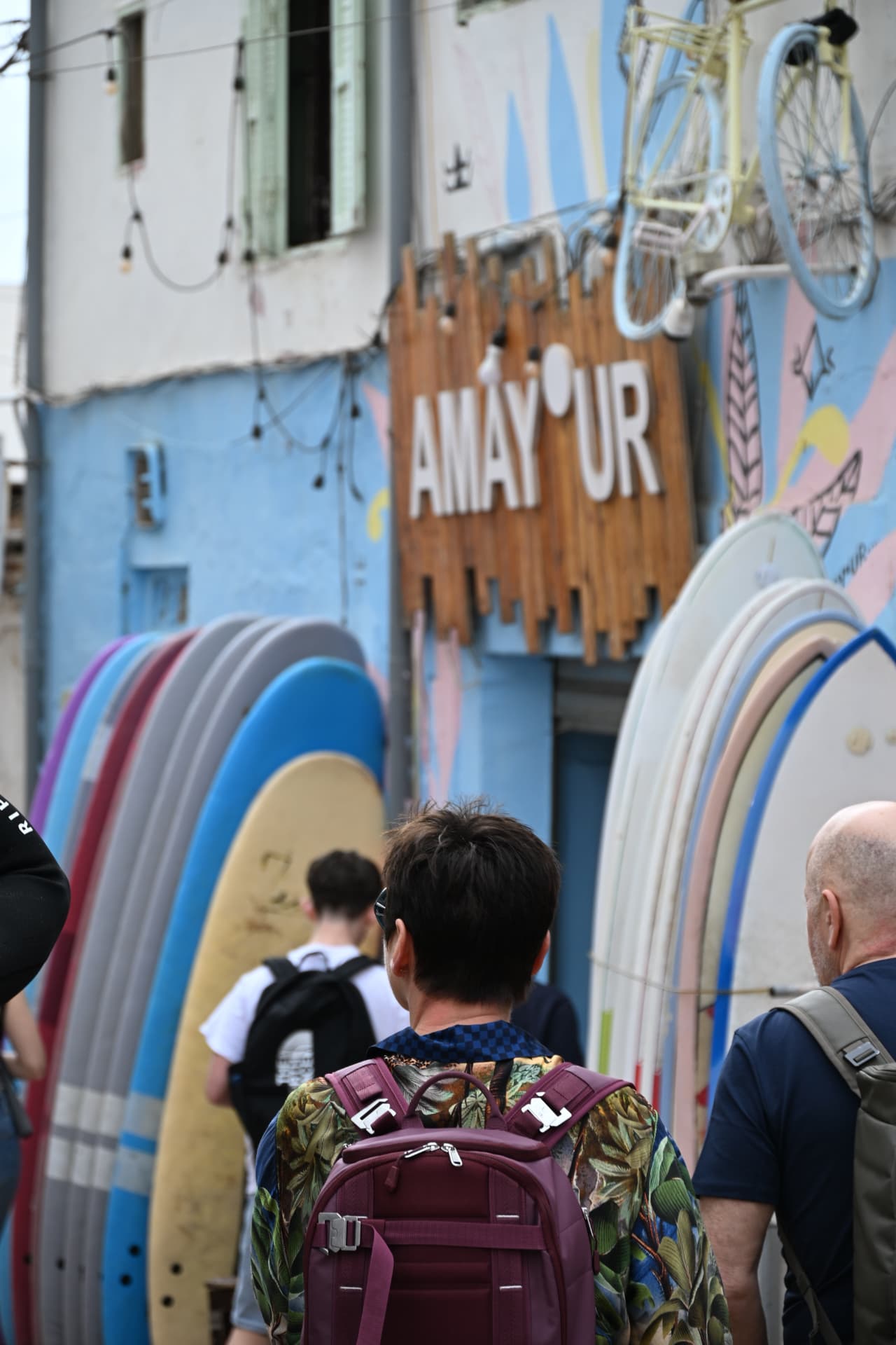 Surfers tussen kleurrijke boards in een straatje