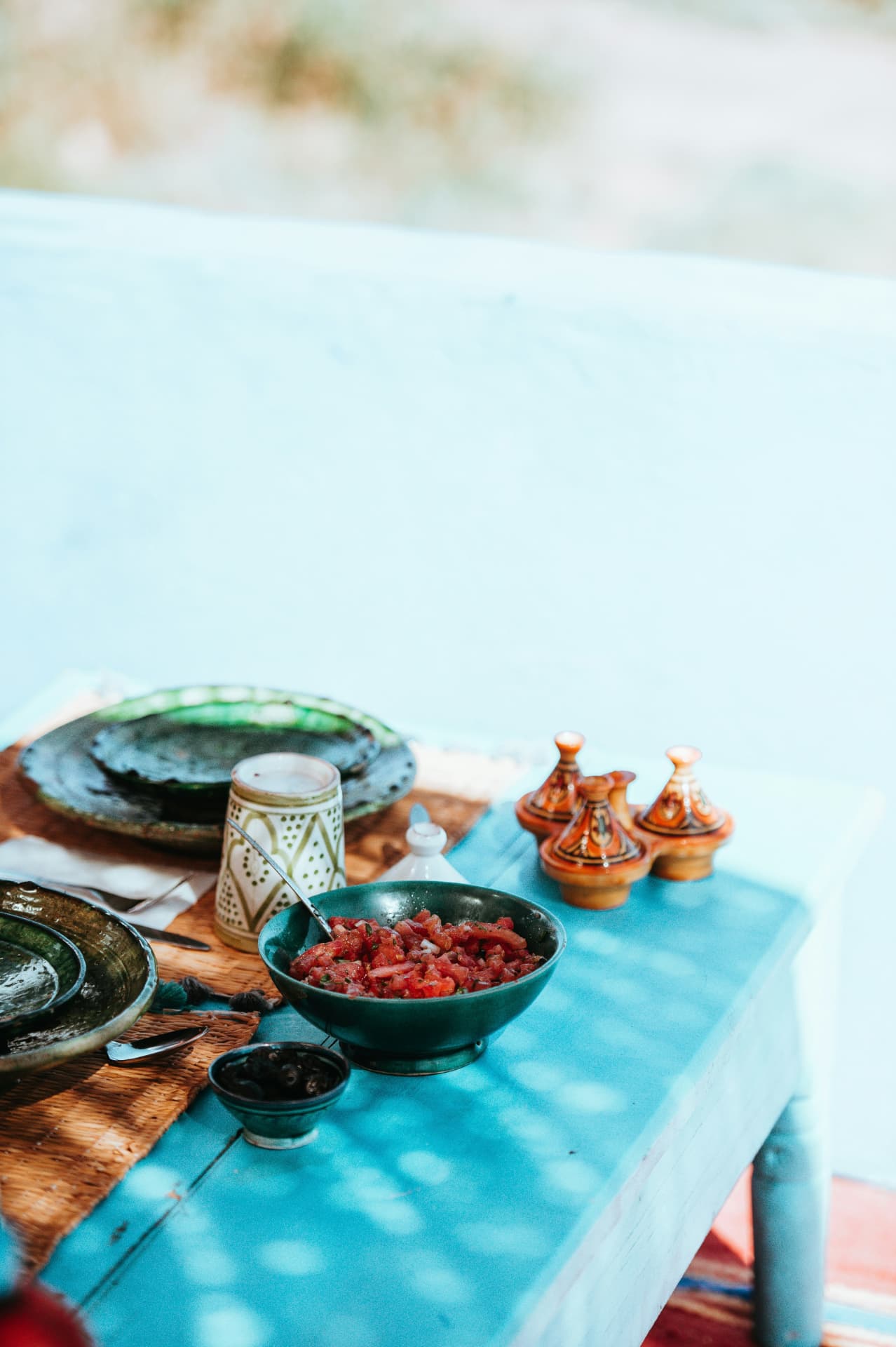 Borden, bekers en tajines op een lichtblauwe tafel