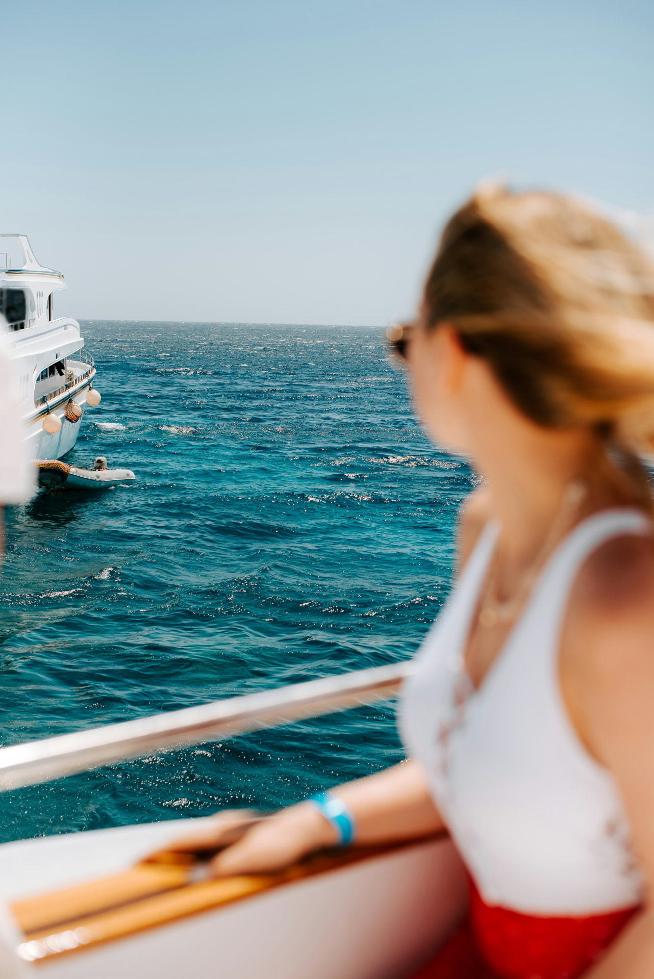 Een vrouw die vanaf een boot uitkijkt over de zee